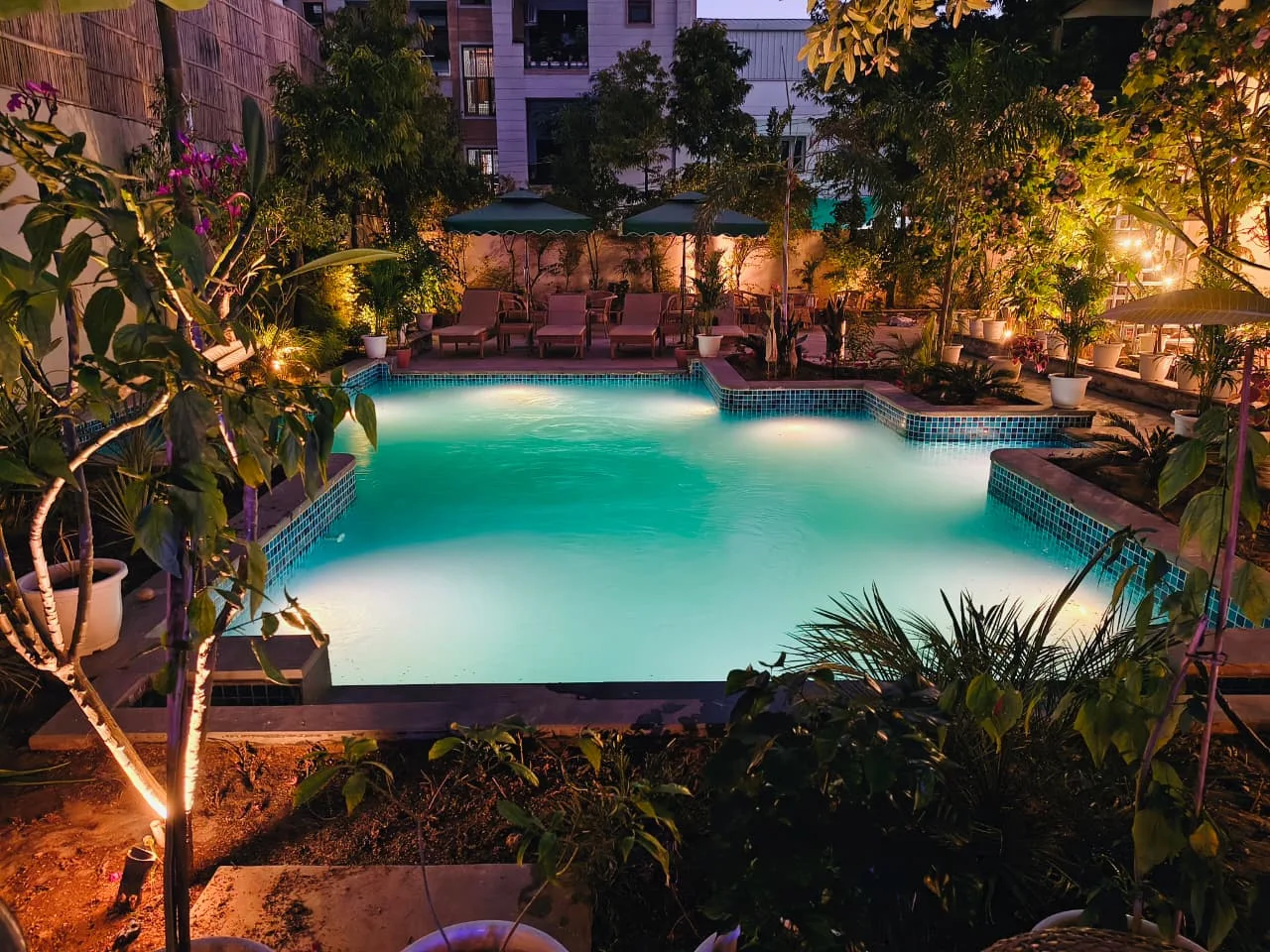 Evening view of the boutique hotel pool surrounded by greenery